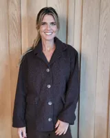 Sobrecamisa de textura tipo corderito en color marrón oscuro, con corte de chaqueta clásica, cuello solapa y cierre frontal de botones. Cuenta con bolsillos frontales con solapa.