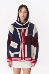 Bufanda de punto color marrón con capucha integrada y bordes en color crema. Presenta una etiqueta rectangular bordada con la palabra Anthea en uno de sus extremos.