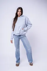 Canguro con capucha color blanco, confeccionado en algodón, con bolsillo frontal tipo canguro y pequeño bordado en el pecho.