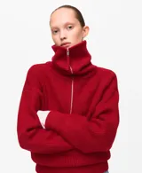 Jersey de punto color rojo, con cuello solapa y cierre frontal parcial de cremallera, de manga larga y diseño holgado.