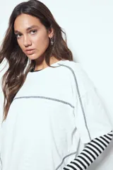 Remera de manga corta con silueta relajada y costuras a la vista en contraste. Presenta un diseño moderno con terminaciones destacadas que aportan un toque distintivo a la prenda.