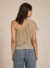 Top color arena de tejido de punto calado, con un solo hombro y volante frontal.