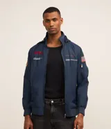 Campera rompevientos azul marino de poliéster, con capucha, cierre frontal de cremallera, bolsillos laterales y estampa temática de la NASA en el frente y mangas.