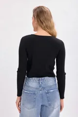 Cárdigan negro de punto canalé con botones frontales y mangas largas.