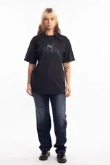 Remera de algodón color negro, con cuello redondo y mangas cortas. Presenta un estampado frontal con una estrella azul y un delfín en el centro, acompañado de tipografía estilo gótico.