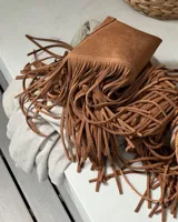 Pechera de cuero vacuno en color negro, diseñada con flecos largos y cierre frontal mediante lazo. Es un accesorio versátil tipo cuello para complementar prendas básicas.