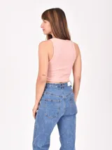 Musculosa corta color rosado, de tela acanalada, con cuello redondo y sisas pronunciadas.