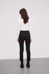 Pantalon de corte slim fit, color negro, con cierre frontal y bolsillos laterales.