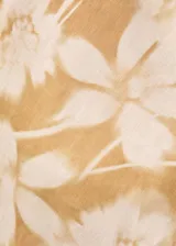 Vestido midi de lino con estampado floral en tonos amarillos y blancos. Presenta un diseño asimétrico con un solo hombro, cintura drapeada y una abertura lateral en el bajo.