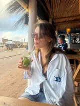 Camisa de algodón a rayas finas blancas y celestes, con cuello sastrero, botones de nácar y bolsillo frontal con bordado de estrella de mar en tonos azules.