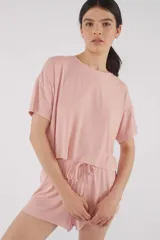 Remera de punto rib color rosa, de corte oversize, con mangas cortas y cuello redondo.