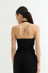 Musculosa negra con escote halter y espalda descubierta.