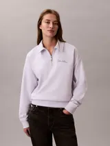 Buzo Calvin Klein de tejido french terry color lila claro, con cuello tipo polo y cierre de media cremallera. Cuenta con el logo de la marca bordado en el pecho y diseño de manga larga.