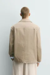 Sobrecamisa relaxed fit color beige confeccionada en tejido de algodón con estructura canvas, cuello solapa, manga larga con trabilla en los puños, bolsillos frontales de plastrón y cierre de botonadura.