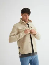 Camisaco color beige confeccionado en sherpa (corderito) con cartera de botones de pasta a tono y bolsillos con solapa en pecho.