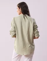 Blusa color beige de poliéster con escote en V y mangas 3/4 regulables con presilla y botón.