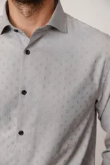 Camisa de vestir gris claro con microestampado geométrico, corte ajustado, cuello clásico y botones negros.