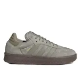 Championes Adidas Samba XLG, color gris claro con suela gruesa de goma marrón oscuro. Presentan un diseño clásico de gamuza con las tres franjas laterales en material sintético y la inscripción "SAMBA" en dorado.