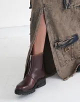 Botas de cuero color marrón con cierre frontal y suela track.