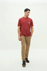 Remera de manga corta color ladrillo con bolsillo en el pecho y estampado pequeño de una palmera.