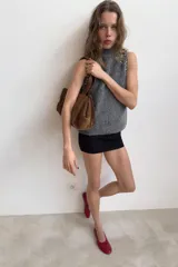 Top sin mangas de punto con mezcla de lana y alpaca, color gris jaspeado. Presenta cuello subido y detalle de abalorios joya en los hombros.