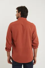 Camisa de manga larga confeccionada en una mezcla de algodón y lino, con cuello abotonado, bolsillo frontal en el pecho y cierre de botones.