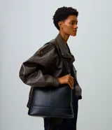 Cartera hobo grande marca Satinato, color negro, confeccionada en cuero con diseño estructurado y asa ajustable para llevar al hombro.