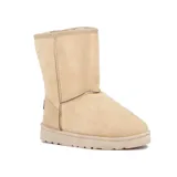 Pantubota de caña media color beige, confeccionada en material tipo gamuza con interior forrado en piel sintética. Presenta costuras reforzadas visibles y suela plana de goma antideslizante.