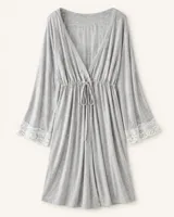 Bata gris melange de modal con mangas acampanadas y detalles de encaje blanco en los puños. Presenta escote en V cruzado y cordón ajustable en la cintura.