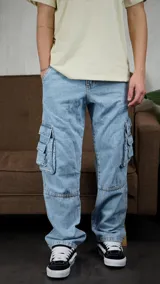 Pantalón cargo de denim en tono azul claro, con corte holgado y bolsillos laterales con solapa en los muslos. Presenta costuras reforzadas en las rodillas y un diseño de estilo urbano.