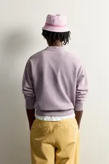 Buzo relaxed fit Fruit of the Loom x Zara color lila con efecto lavado, cuello redondo y manga larga. Estampación frontal de texto multicolor y acabado en rib.