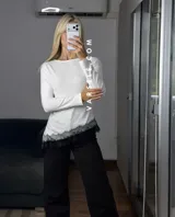 Blusa de manga larga color marrón, con corte asimétrico y detalle de puntilla blanca en el ruedo. Confeccionada en tejido de algodón y viscosa.