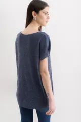 Blusa de punto con acabado brillante, cuello redondo y mangas cortas con caída relajada.