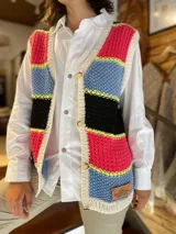 Chaleco tejido a mano de hilo de algodón, con diseño de franjas horizontales en colores fucsia, celeste, negro y detalles en amarillo flúor, escote en V y cierre frontal con botones.