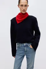 Jean de tiro alto con corte acampanado desde la rodilla y bajo deshilachado. Presenta diseño clásico de cinco bolsillos, cierre frontal con botón y costuras reforzadas en el ruedo.