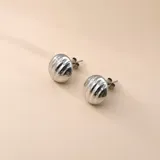 Par de aros tipo botón con diseño semiesférico y textura acanalada, fabricados en plata 925.