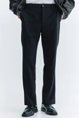 Pantalón sastrero negro de corte slim fit, con presillas para cinto, bolsillos laterales al bies y bolsillos traseros ojalados.