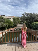 Falda larga tejida a rayas verticales rojas y blancas, con pretina elástica y tajos laterales.