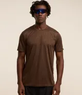 Remera deportiva de cuello redondo y manga corta, confeccionada en tejido con tecnología Dry de alta transpirabilidad. Presenta un diseño con estampa sutil y detalles de líneas en los hombros.