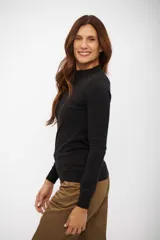 Sweater de punto tipo media polera en color negro, de calce entallado y manga larga. Presenta cuello alto y terminaciones acanaladas en puños y cintura.