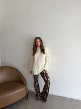 Pantalón tipo oxford de tiro alto, con estampado abstracto en tonos tierra, negro y crema. Presenta un corte ajustado en la parte superior y acampanado desde la rodilla hacia abajo.
