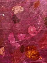 Mantel rectangular de lino color rosa con estampado de hojas y flores en tonos naranja, marrón y blanco.