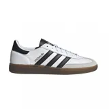 Championes Adidas Handball Spezial con diseño clásico de perfil bajo. Presentan una base de cuero blanco con las icónicas tres rayas laterales en negro, refuerzo de gamuza gris en la puntera y suela de goma color caramelo.