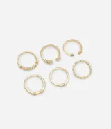 Set de seis anillos dorados de metal con acabado en baño dorado claro, que incluye diseños variados con incrustaciones de strass, aberturas ajustables y una argolla de diseño ondulado.