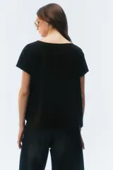 Remera negra de corte evasé y largo corto, con escote redondo y mangas cortas.
