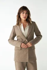 Blazer largo color crema con cuello solapa, bolsillos con solapa y forro interior combinado a tono. Confeccionado en lana fina sin teñir.