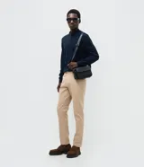 Suéter de punto color marrón, con cuello alto y cierre frontal parcial tipo half-zip, de manga larga y diseño regular.