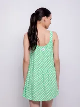 Vestido corto blanco con estampado floral en tonos naranja y lila, de corte suelto y sin mangas.