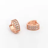 Par de aros tipo argolla color oro rosa con cristales blancos incrustados.