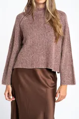 Sweater de tejido de punto con cuello alto, mangas largas y diseño holgado. Presenta un patrón de rayas verticales en tonos malva y beige.